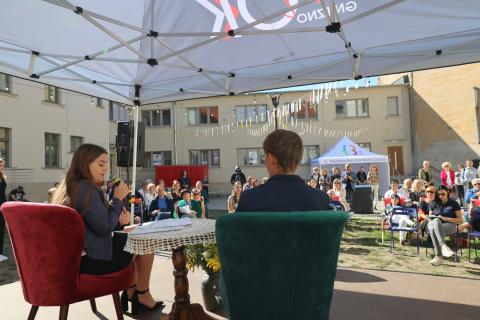 Dziedziniec Starego Ratusza, na scenie chłopak i dziewczyna, którzy biorą udział w przedstawieniu "Nadmienieńska sprawa dla reportera" w tle zdromadzona publiczność.